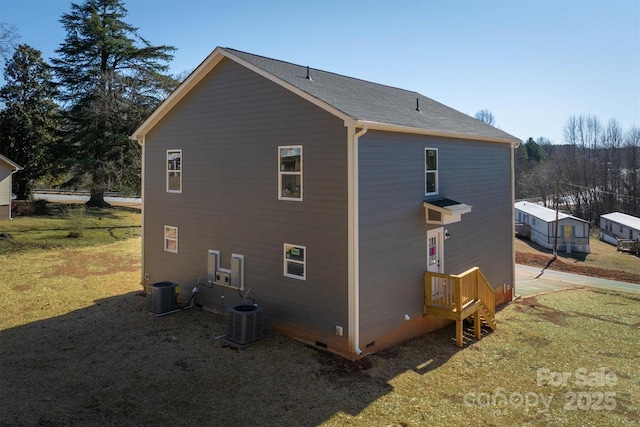 view of side of property with cooling unit and a lawn