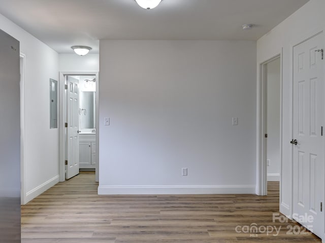 unfurnished room with electric panel and light wood-type flooring