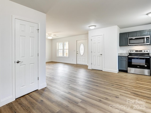 foyer entrance with ceiling fan and light hardwood / wood-style flooring