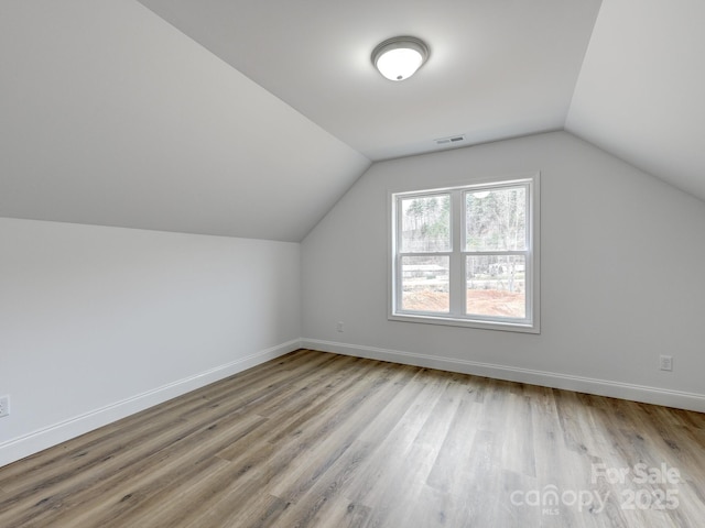 additional living space with lofted ceiling and light wood-type flooring