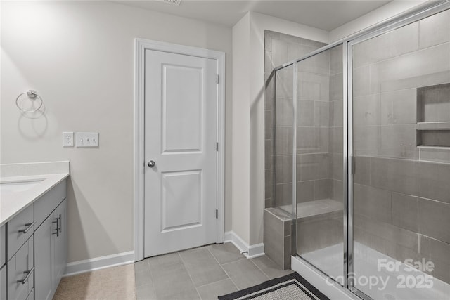 bathroom with tile patterned flooring, walk in shower, and vanity