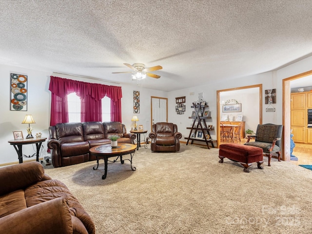 carpeted living room with ceiling fan and a textured ceiling