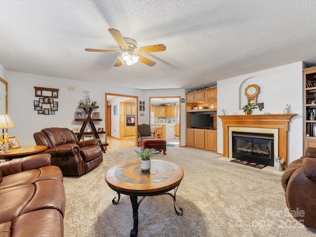 living room with ceiling fan, light colored carpet, a textured ceiling, and built in shelves