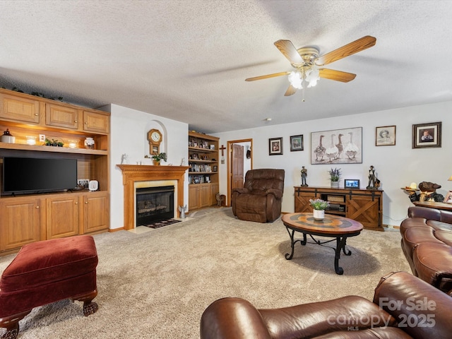 carpeted living room featuring ceiling fan, built in features, and a textured ceiling