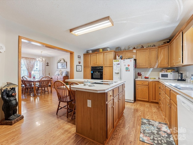 kitchen with a kitchen island, a textured ceiling, light wood-type flooring, and black appliances