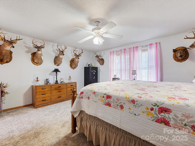 bedroom with carpet, a textured ceiling, and ceiling fan