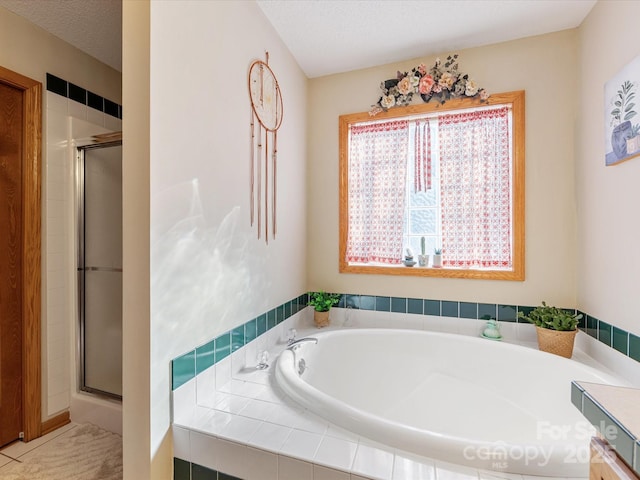 bathroom with separate shower and tub, tile patterned flooring, and a textured ceiling