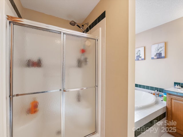 bathroom featuring vanity, independent shower and bath, and a textured ceiling