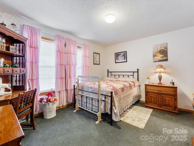 bedroom with multiple windows, dark colored carpet, and a textured ceiling