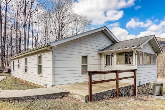 view of side of home featuring a patio area, cooling unit, and a sunroom