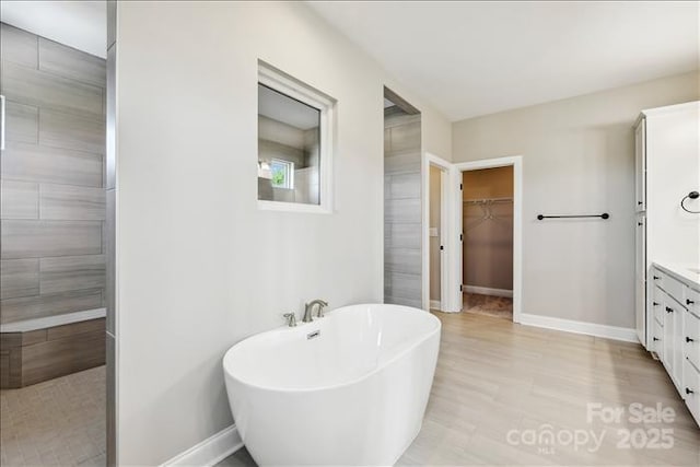 bathroom featuring hardwood / wood-style flooring, independent shower and bath, and vanity