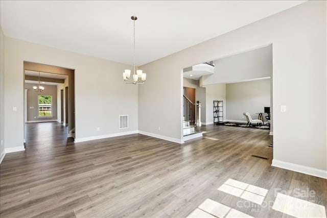 spare room featuring hardwood / wood-style floors and a chandelier