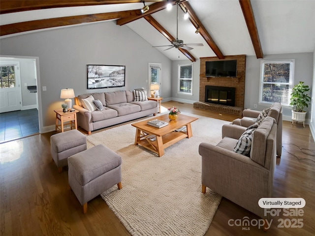 living room featuring a fireplace, ceiling fan, lofted ceiling with beams, and plenty of natural light