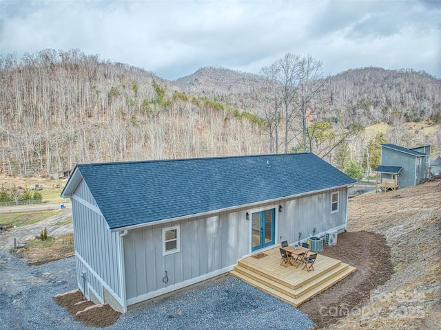 rear view of property featuring a deck with mountain view and central air condition unit