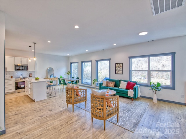 living room featuring light hardwood / wood-style floors and a wealth of natural light