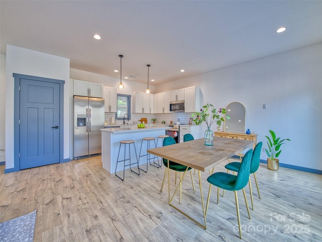 dining space with light hardwood / wood-style floors and sink