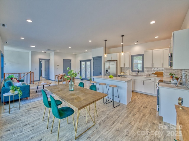 dining space with sink, plenty of natural light, and light hardwood / wood-style flooring