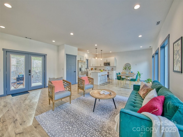 living room featuring light hardwood / wood-style floors and french doors