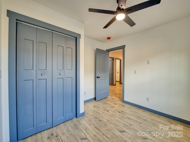 unfurnished bedroom featuring ceiling fan, light wood-type flooring, and a closet