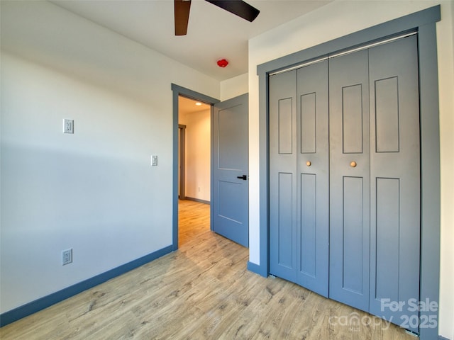 unfurnished bedroom with ceiling fan, light hardwood / wood-style floors, and a closet