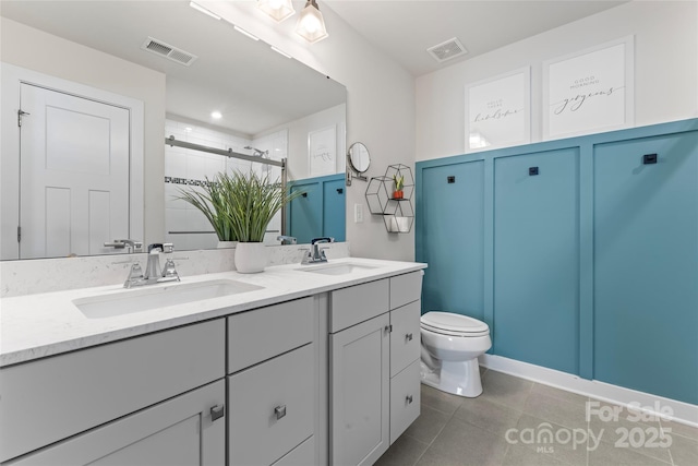 bathroom featuring a shower with shower door, tile patterned floors, toilet, and vanity