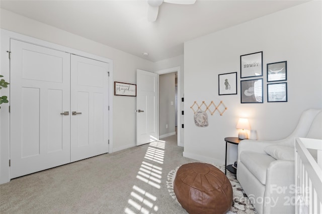 living area featuring light carpet and ceiling fan