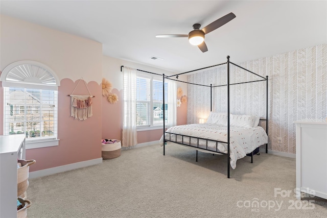 carpeted bedroom featuring ceiling fan and multiple windows