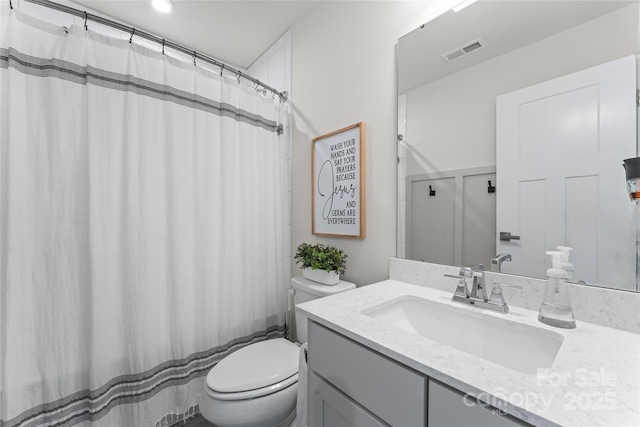 bathroom with toilet, vanity, and a shower with shower curtain