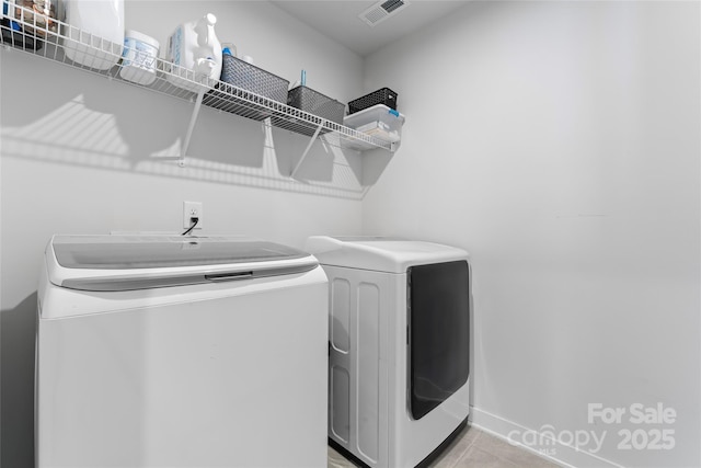 washroom with light tile patterned floors and washing machine and clothes dryer