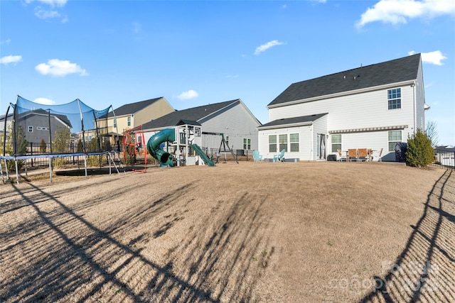 back of property with a playground and a trampoline