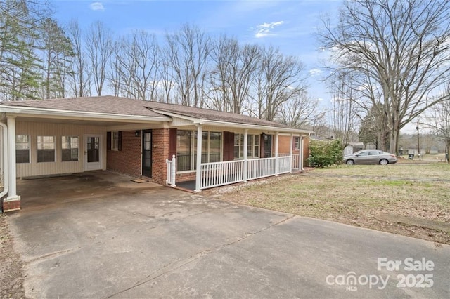 single story home with a carport, a front yard, and covered porch