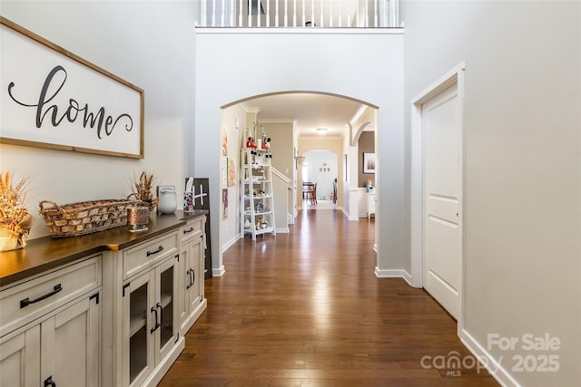 corridor featuring ornamental molding and dark hardwood / wood-style flooring