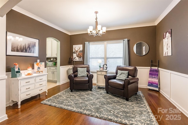 sitting room with dark hardwood / wood-style flooring, a notable chandelier, and ornamental molding