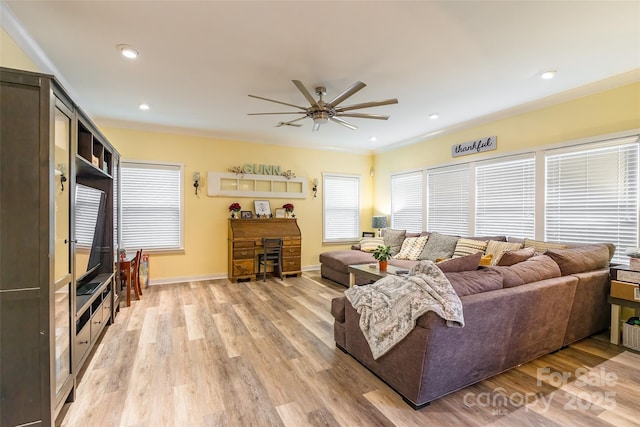 living room with ornamental molding, light hardwood / wood-style floors, and ceiling fan