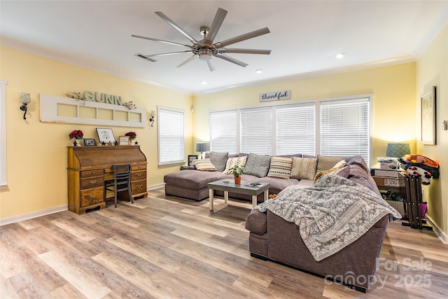 living room featuring crown molding, ceiling fan, and light hardwood / wood-style flooring