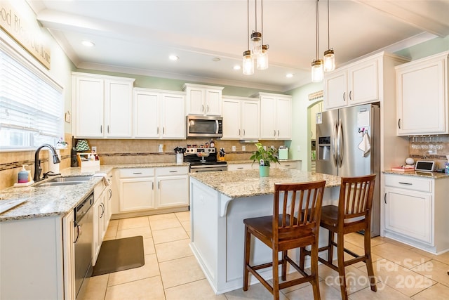 kitchen with white cabinetry, sink, decorative backsplash, a center island, and stainless steel appliances