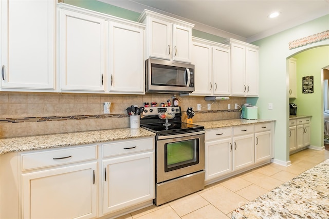 kitchen featuring tasteful backsplash, white cabinets, light tile patterned floors, light stone counters, and stainless steel appliances