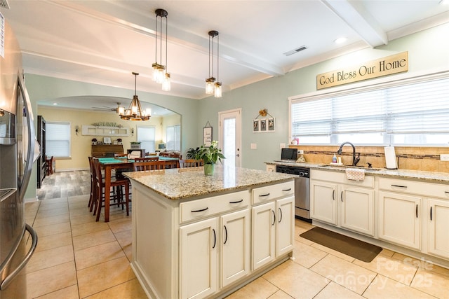 kitchen featuring sink, hanging light fixtures, appliances with stainless steel finishes, a kitchen island, and beam ceiling