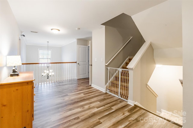 hallway featuring hardwood / wood-style flooring and a notable chandelier