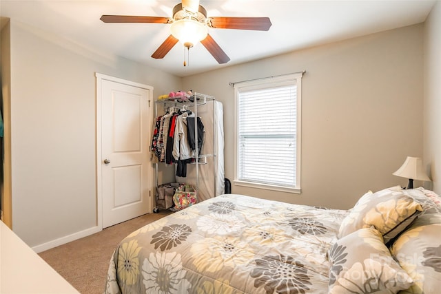 bedroom with light colored carpet, ceiling fan, and a closet