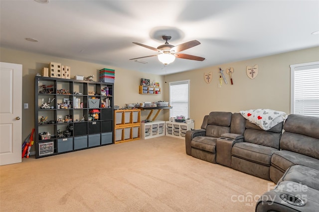 carpeted living room with ceiling fan