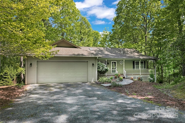 view of front of home with a porch, an attached garage, driveway, and roof with shingles