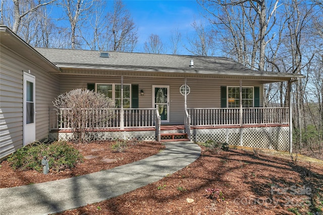 ranch-style home featuring covered porch and roof with shingles
