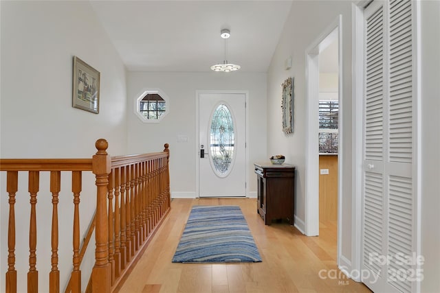 foyer entrance with light wood-type flooring and baseboards