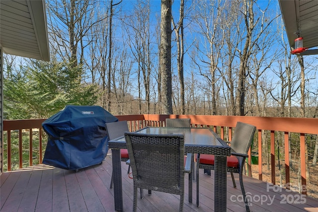 wooden terrace featuring outdoor dining area and grilling area