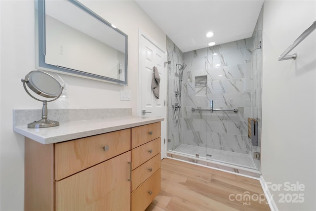 full bath featuring a stall shower, recessed lighting, vanity, and wood finished floors