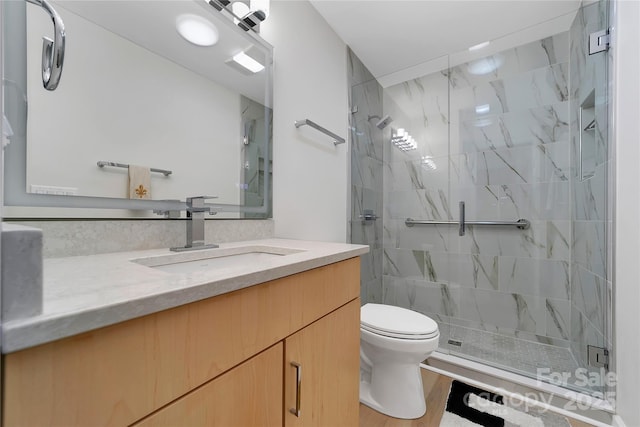 full bath with a stall shower, toilet, and vanity
