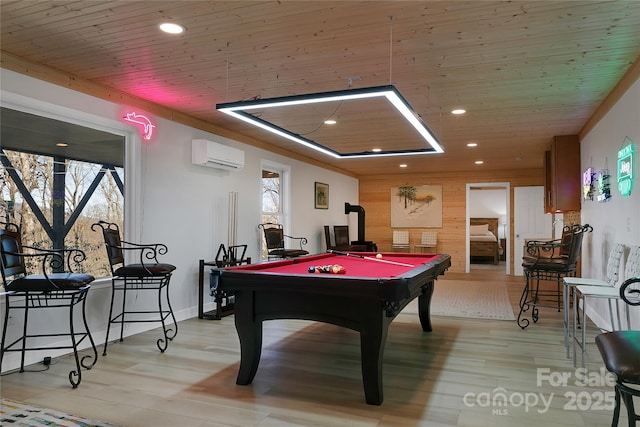 game room with billiards table, wood ceiling, an AC wall unit, light wood-style floors, and wooden walls