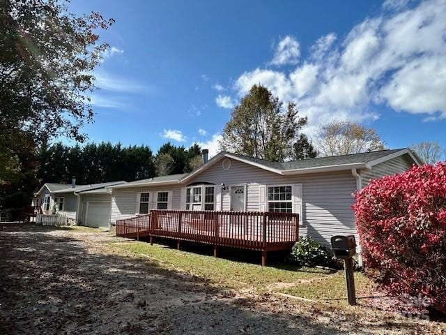 back of property featuring a garage and a wooden deck