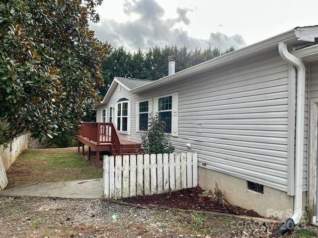 view of property exterior with a wooden deck